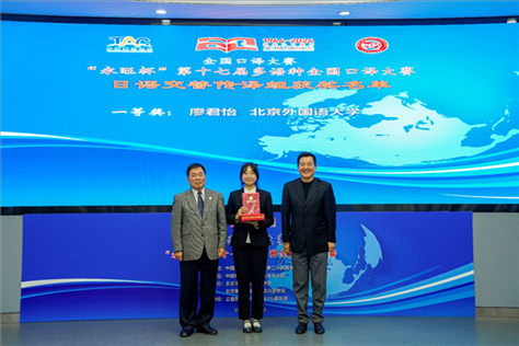 中國(guó)翻譯協(xié)會(huì)副會(huì)長(zhǎng)中國(guó)外文局中東歐與中南亞傳播中心（人民畫報(bào)社）主任姜永鋼（右一）、原中國(guó)教育工會(huì)全國(guó)委員會(huì)巡視員白立文（左一）為獲得日語(yǔ)交傳組一等獎(jiǎng)的北京外國(guó)語(yǔ)大學(xué)廖君怡頒獎(jiǎng)（主辦方提供）
