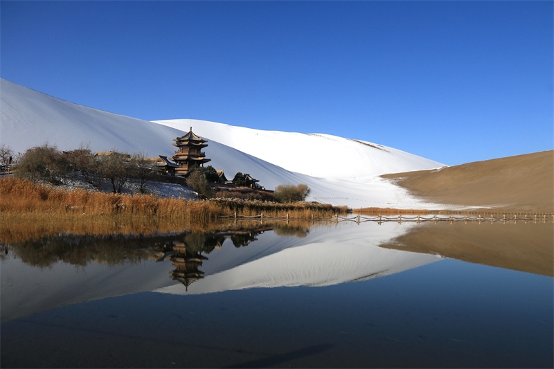 鳴沙山月牙泉景區(qū)雪景。敦煌市委宣傳部供圖，張曉亮攝