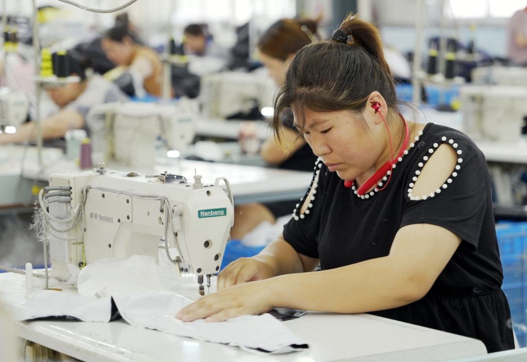 5月20日，村民在李寨村服裝加工廠內(nèi)忙碌。河南省周口市沈丘縣馮營(yíng)鎮(zhèn)李寨村地處豫東平原。近年來(lái)，乘著脫貧攻堅(jiān)與鄉(xiāng)村振興政策的東風(fēng)，李寨村積極探索產(chǎn)業(yè)發(fā)展模式，通過(guò)“龍頭企業(yè)+村集體經(jīng)濟(jì)+農(nóng)戶”的方式，逐漸發(fā)展形成肉牛養(yǎng)殖、設(shè)施農(nóng)業(yè)、服裝加工、康養(yǎng)民宿等產(chǎn)業(yè)，以產(chǎn)業(yè)振興助力鄉(xiāng)村振興。新華社記者 李嘉南 攝