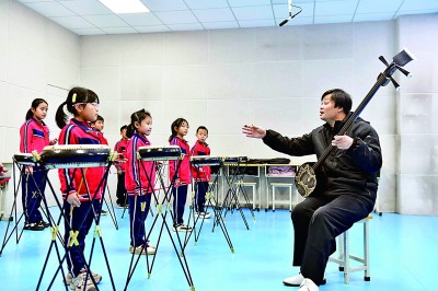 圖為12月30日，在惠民縣胡集鎮(zhèn)第一小學(xué)，老師指導(dǎo)學(xué)生學(xué)習(xí)西河大鼓。新華社記者 郭緒雷攝