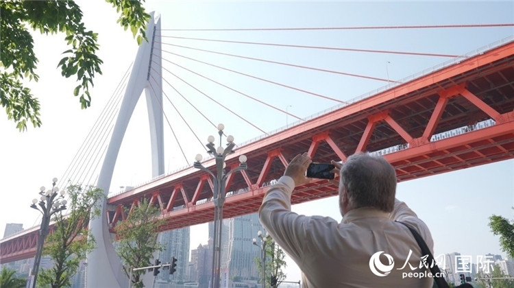 軻寶華“打卡”重慶東水門長江大橋。人民網(wǎng)記者 蘇纓翔攝