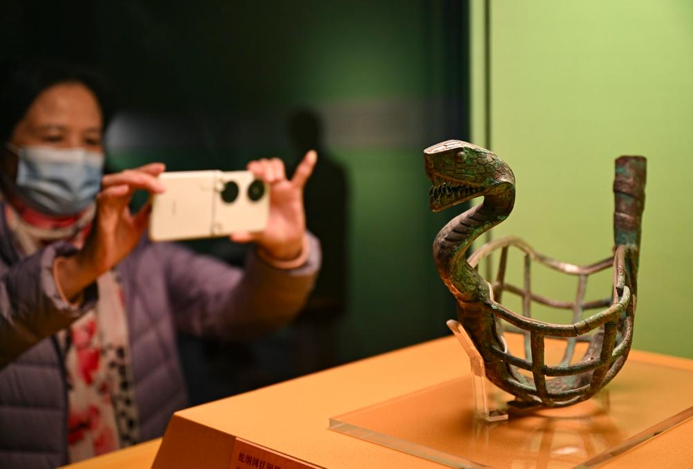 1月14日，觀眾在上海博物館蛇年迎春展拍攝展品蛇綱網(wǎng)狀銅器。新華社發(fā)（陳浩明攝）