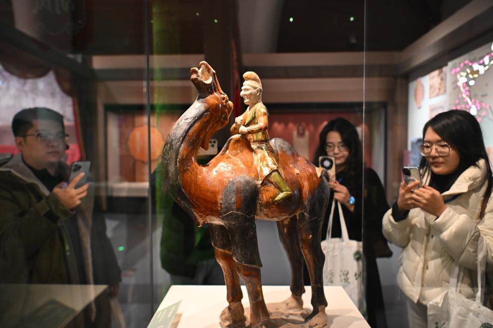 1月15日，觀眾在拍攝“長安三萬里——陜西唐代文物精華展”展出的三彩胡人騎駝俑。（新華社記者 孫凡越 攝）