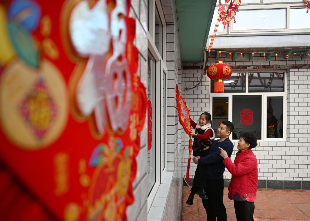 天津市西青區(qū)辛口鎮(zhèn)第六埠村村民在院子里掛“福”字（2024年2月1日攝）。新華社記者 趙子碩 攝