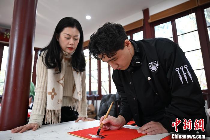 1月20日，外籍留學(xué)生在西泠印社社員李硯指導(dǎo)下寫福。當日，來自巴西、馬來西亞、加納、哈薩克斯坦的外籍留學(xué)生在浙江杭州西泠印社體驗福貼、春聯(lián)和篆刻，感受古老的中國傳統(tǒng)文化。中新社記者 王剛 攝