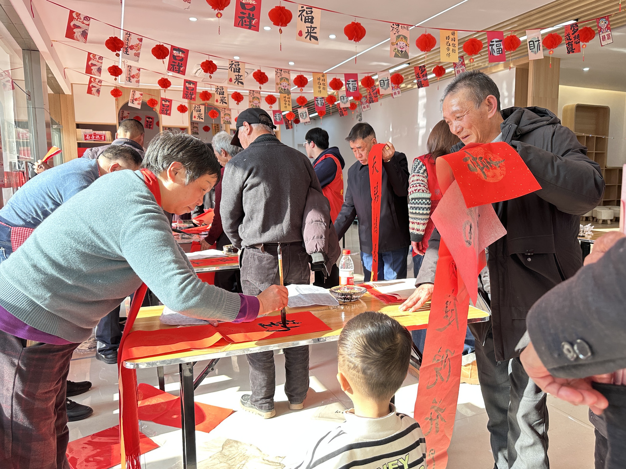 今年春節(jié)前夕，慶元縣濛洲街道同濟(jì)新村，一場送春聯(lián)活動熱鬧舉行。慶元縣融媒體中心 供圖
