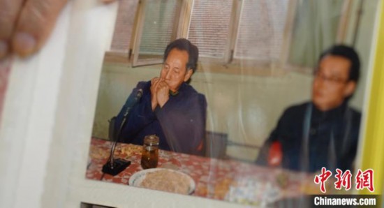 2月7日，劉潤林展示1986年黃旭華(左)在同樂會上吹口琴的老照片。中新社記者 鄒浩 攝