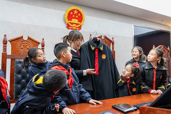 圖②：干警向同學(xué)們介紹法袍。