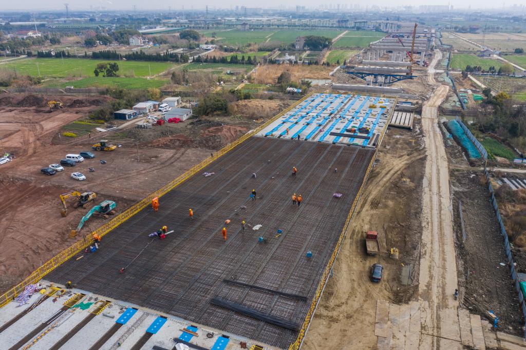 3月7日，在524國道秀洲王江涇至新塍公路工程TJ02標(biāo)段，作業(yè)人員正在進(jìn)行60米鋼混組合梁現(xiàn)澆橋面板鋼筋焊接及綁扎作業(yè)（無人機(jī)照片）。新華社記者 徐昱 攝