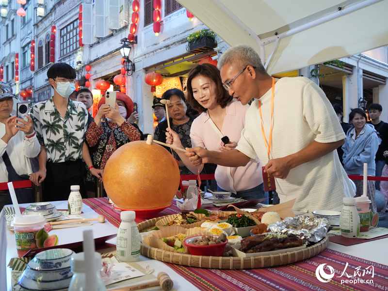 嘉賓品嘗海南傳統(tǒng)美食“煎堆”。人民網(wǎng)記者 張力洋攝