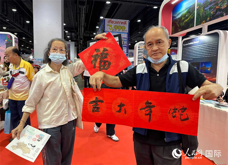 2025蛇年春節(jié)，泰國市民展示他們領(lǐng)到的華人手寫春聯(lián)。人民網(wǎng)記者 簡承淵攝