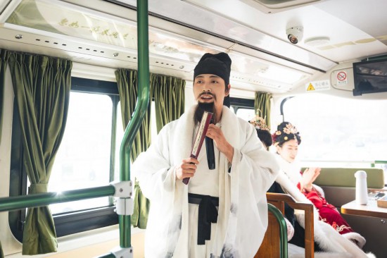 身著古裝的“伴游”在“長安尋夢”主題觀光車上為游客講解。（受訪者供圖）