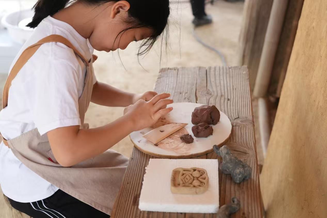 游客制作良渚特色陶藝品。良渚博物院供圖