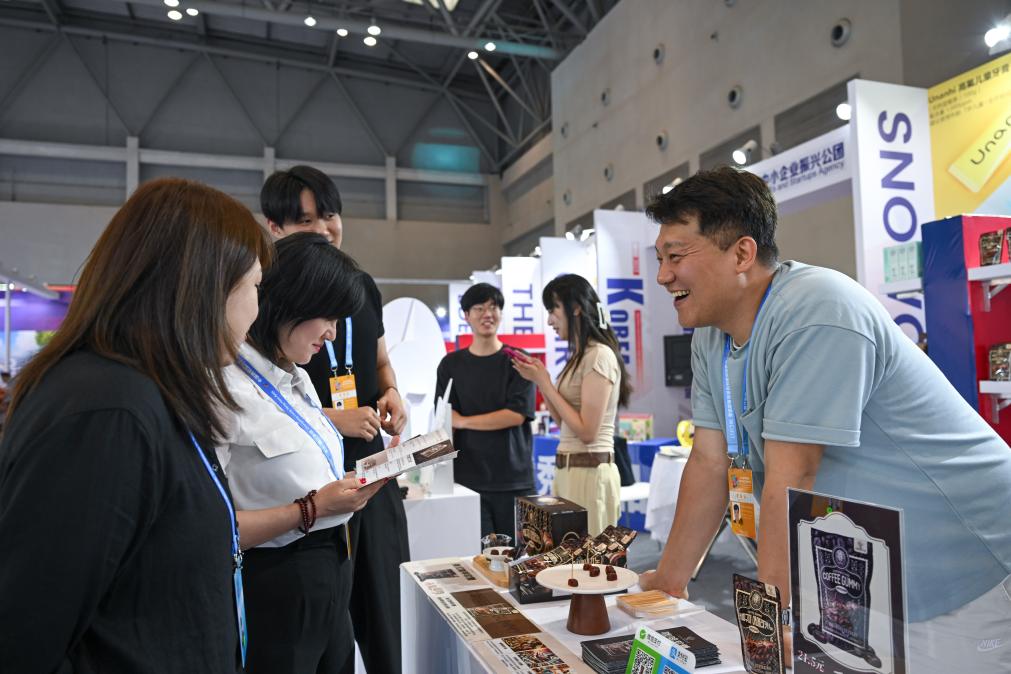 5月22日，韓國(guó)展商（右一）在西洽會(huì)現(xiàn)場(chǎng)向參觀者介紹產(chǎn)品。新華社記者 陳誠(chéng) 攝