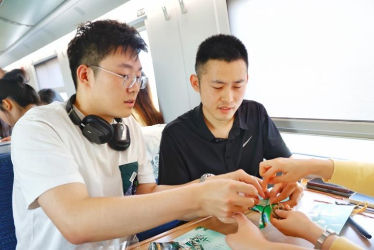 G232次旅客親手制作端午荷包和五彩繩。王磊攝