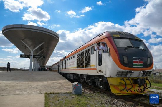 5月31日，在蒙內(nèi)鐵路內(nèi)羅畢站，機(jī)車(chē)駕駛員蔣立平（右）和博爾在即將開(kāi)往蒙巴薩的E2次列車(chē)上揮手致意。新華社記者 楊光 攝