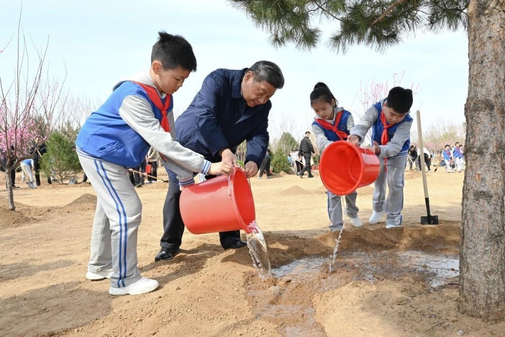 2025年4月3日，習(xí)近平總書(shū)記等來(lái)到北京市豐臺(tái)區(qū)永定河畔參加首都義務(wù)植樹(shù)活動(dòng)。這是習(xí)近平總書(shū)記同少先隊(duì)員一起給剛栽下的樹(shù)苗澆水。新華社記者 謝環(huán)馳 攝