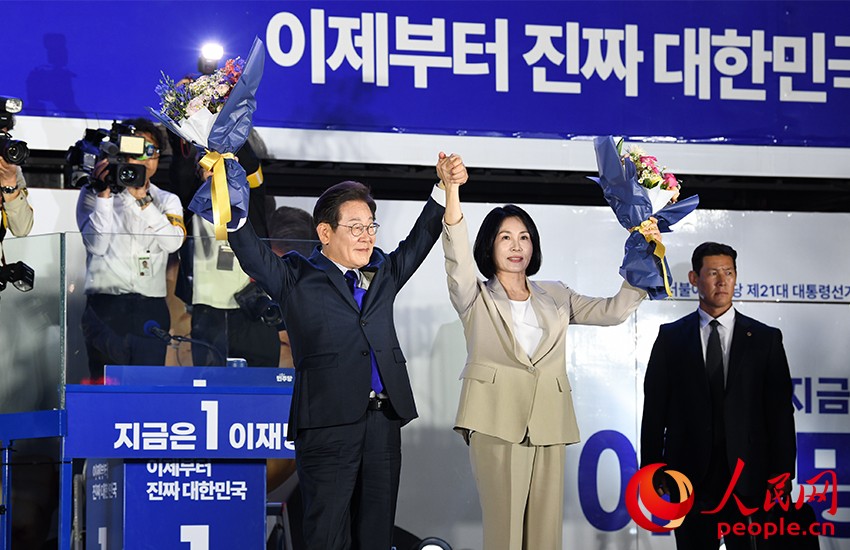 6月4日凌晨，確定當(dāng)選韓國(guó)總統(tǒng)的李在明舉手向歡呼的支持者們致意。 人民網(wǎng) 康炯彬攝